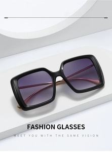 Détail de lunettes de soleil carrées avec verres dégradés violets et branches dorées