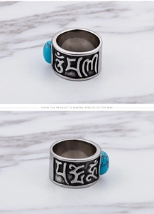Macro shot of vintage stainless steel ring featuring Sanskrit relief and turquoise inlay