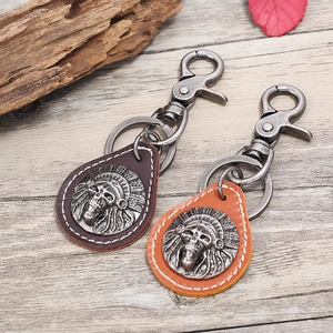 Retro leather keychain with skull badge in brown and orange on rustic wood