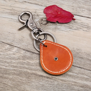 Porte-clés vintage en cuir avec croix en métal sur pendentif marron sur fond de bois