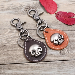 Retro punk leather keychain with metal skull charms in dark brown and orange colors