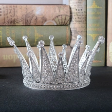 Close-up of a sparkling silver princess crown with crystal rhinestones on vintage books