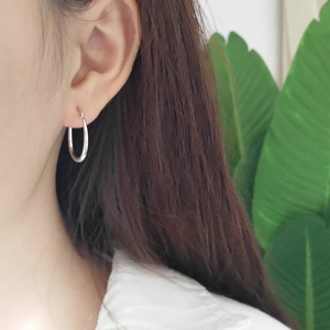 Close-up of a model wearing a minimalist 925 sterling silver horseshoe U-shaped earring