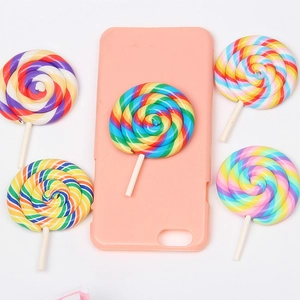 Pink phone case decorated with rainbow lollipop resin charms on a clean white background