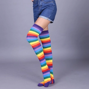 Detail of colorful rainbow striped knit leg warmers worn over the knee with denim shorts