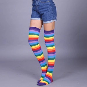 Detail view of rainbow striped over-knee high socks with soft knitted texture on model