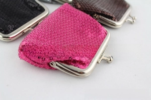 Macro detail van pailletten portemonnees in roze, zwart en bruin met metalen sluiting
