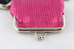 Detail van rozerode pailletten portemonnee met zilveren kiss-clasp sluiting en metalen frame