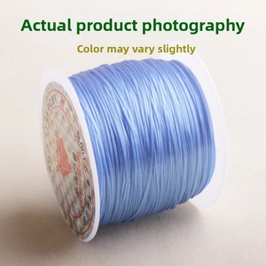 Close-up of blue crystal elastic string for jewelry making on a white plastic spool