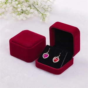 Close-up of heart crystal earrings inside a luxury burgundy velvet jewelry gift box