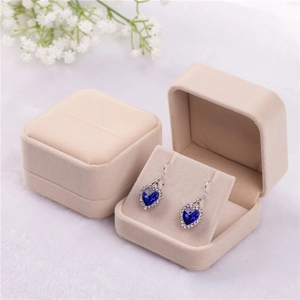 Square beige velvet jewelry box shown open and closed with heart earrings inside
