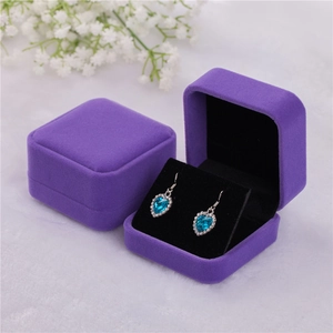 Detail of blue heart gemstone earrings with diamonds in a purple velvet jewelry box