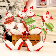 Vue détaillée des cache-oreilles de Noël en peluche avec motifs Père Noël et renne
