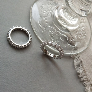 S925 sterling silver eternity band rings with clear cubic zirconia on grey fabric