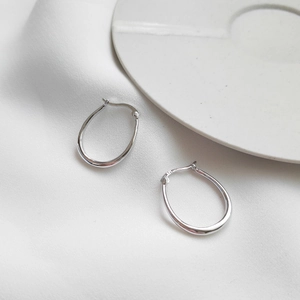 925 sterling silver U-shaped hoop earrings displayed on white silk with a ceramic tray