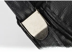 Macro detail of the adjustable silver metal buckle on a black textured leather cap