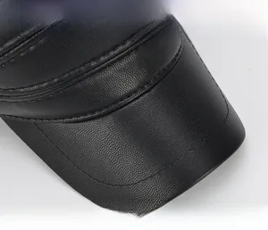 Macro detail of the wide thickened brim on a black faux leather winter hat for men