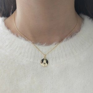Close-up of gold Virgin Mary pendant on silver chain featuring polished Italy hallmark