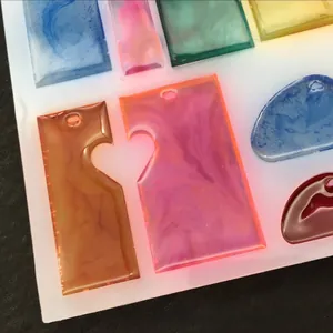 Detail of translucent silicone molds for DIY resin pendants in puzzle and teardrop shapes