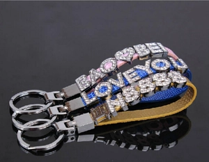 Detail of pink, blue and yellow leather wristbands with rhinestone alphabet letters charms