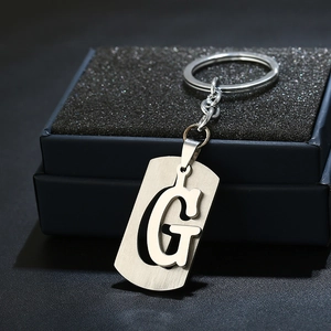 Macro shot of silver stainless steel keychain with minimalist hollow letter G pendant