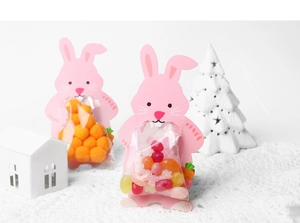 Close-up of cute pink rabbit candy packaging cards with carrot patterns on white background