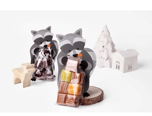 Close-up of cute raccoon paper candy holders with caramel packs on a decorative white setup