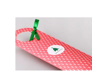 Close-up of Christmas gift tags with festive red card and green ribbon bow details