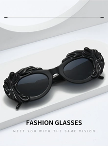 Détail de lunettes de soleil ovales noires avec bords ondulés en relief sur socle