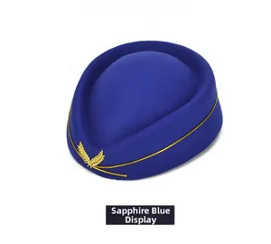 Detail of sapphire blue wool felt stewardess hat with gold trim and metallic badge