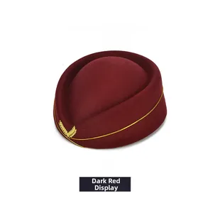 Close-up of a dark red wool pillbox hat with gold trim and embroidered wheat badge