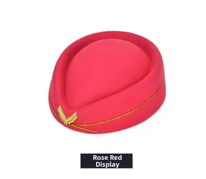 Detail of rose red pillbox hat featuring gold wheat badge and braided trim decoration