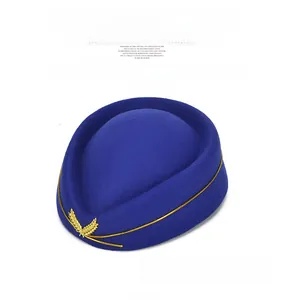 Close-up of royal blue pillbox hat featuring golden leaf embroidery and braided rope trim
