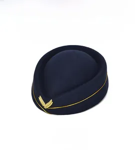 Detail of navy blue wool felt stewardess hat with gold wheat badge and decorative trim