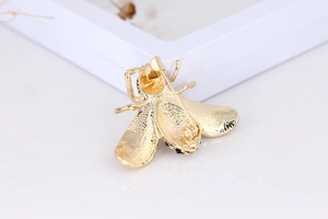 Detail view of the gold-plated bee brooch back showing the secure pin fastener