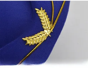 Close-up of dark blue felt uniform hat with gold leaf metallic decor and woven rope detail