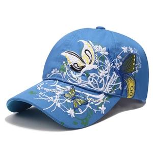 Berretto blu con ricamo a farfalla floreale e paillettes su sfondo bianco