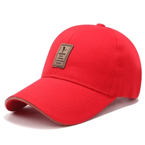 Dettaglio del cappellino da baseball rosso in cotone con toppa in pelle e profilo