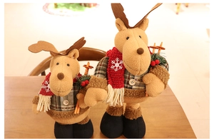 Detail of two Christmas reindeer plush dolls with retractable legs on wooden background