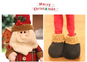 Detail of Christmas Santa plush showing facial features and plaid fabric craftsmanship