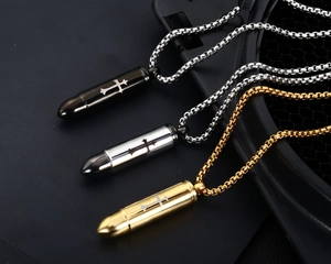 Three bullet necklaces in black, gold, and silver with engraved crosses on metal