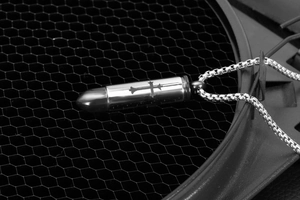 Macro shot of silver stainless steel bullet cross pendant urn necklace with chain