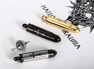 Detail of bullet-shaped urn pendants in gold, black and silver with a filling funnel set