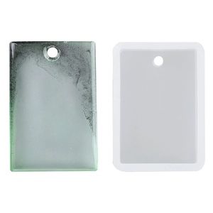 Vista macro dello stampo in silicone e del ciondolo in resina traslucida con foro di aggancio