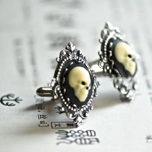 Macro shot of silver baroque skull cufflinks with vintage embossed details and black base