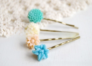 Detail showing macaron pastel resin flower hair clips with golden wavy metal base