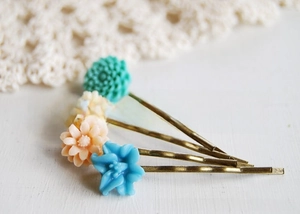 Close-up of four baroque resin rose hair clips in vintage bronze finish with pastel petals