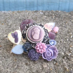 Detailed macro view of retro purple cameo and floral charms for DIY jewelry making