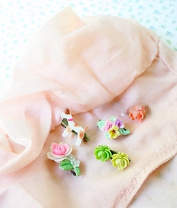 Detailed view of handmade resin dog and flower pendants on soft pink tulle fabric