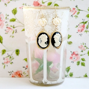 Detail view of vintage cameo drop earrings with white resin rose and golden frame